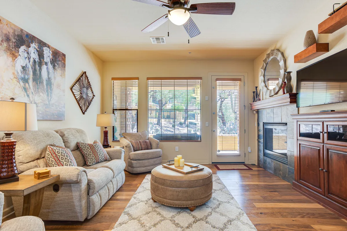 A cozy living room with a plush sofa, fireplace, coffee table, and artwork. The soft lighting and inviting decor set the scene for relaxing, reading, or hosting movie nights.